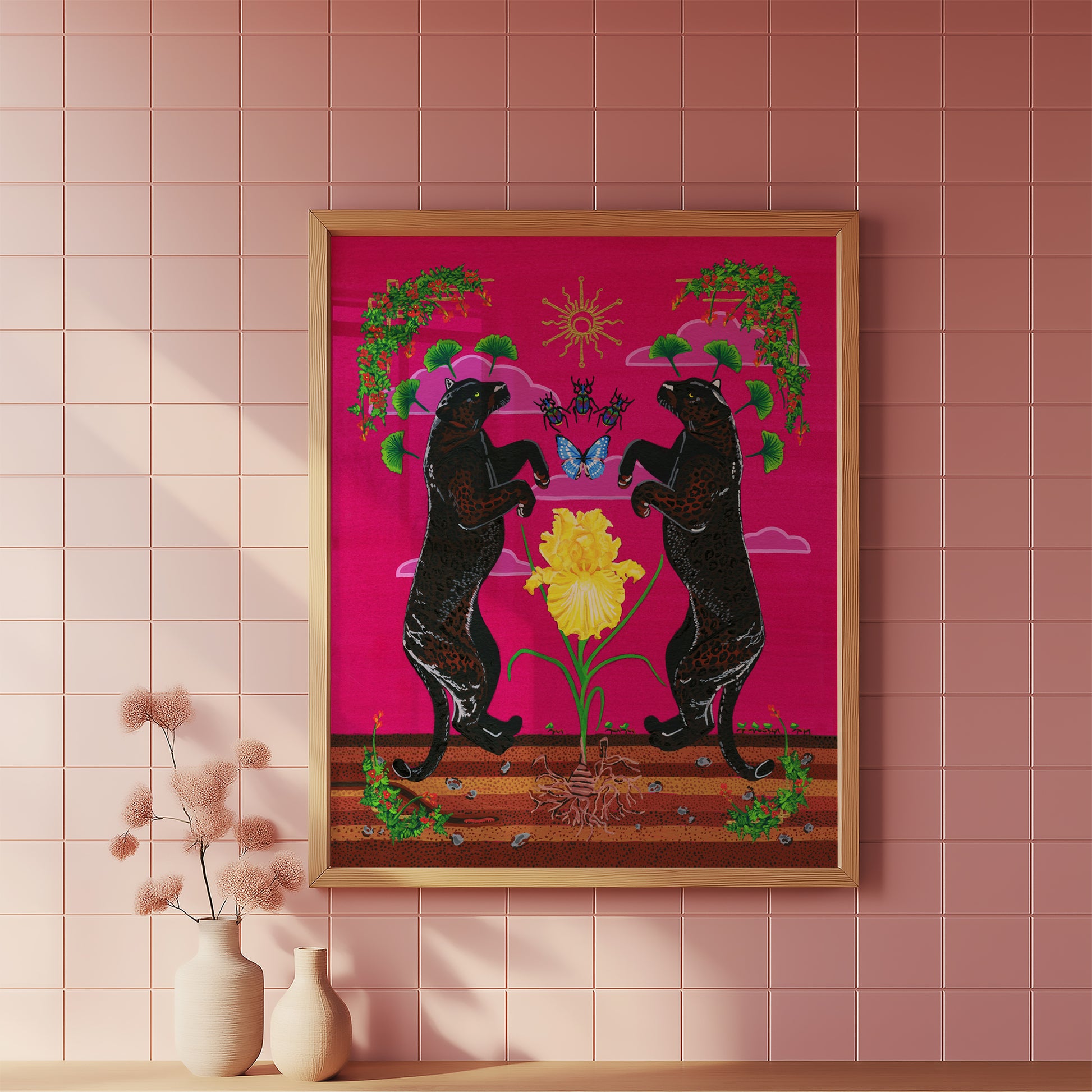 Framed black panther art print displayed in a light wood frame on a pink tiled wall, styled over a wooden shelf next to two cream-colored ceramic vases with dried botanicals.