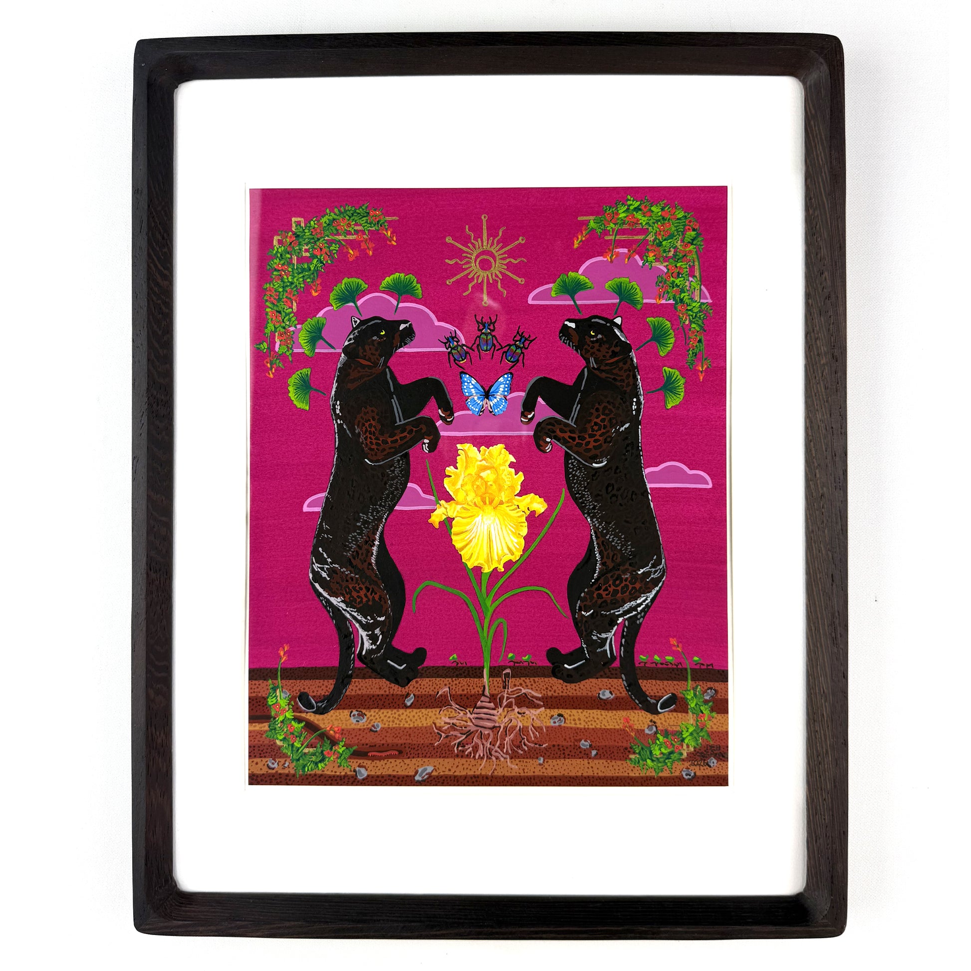 Framed original art featuring two black panthers facing each other around a bright yellow iris on a pink background, enclosed in a white mat and dark wood frame.