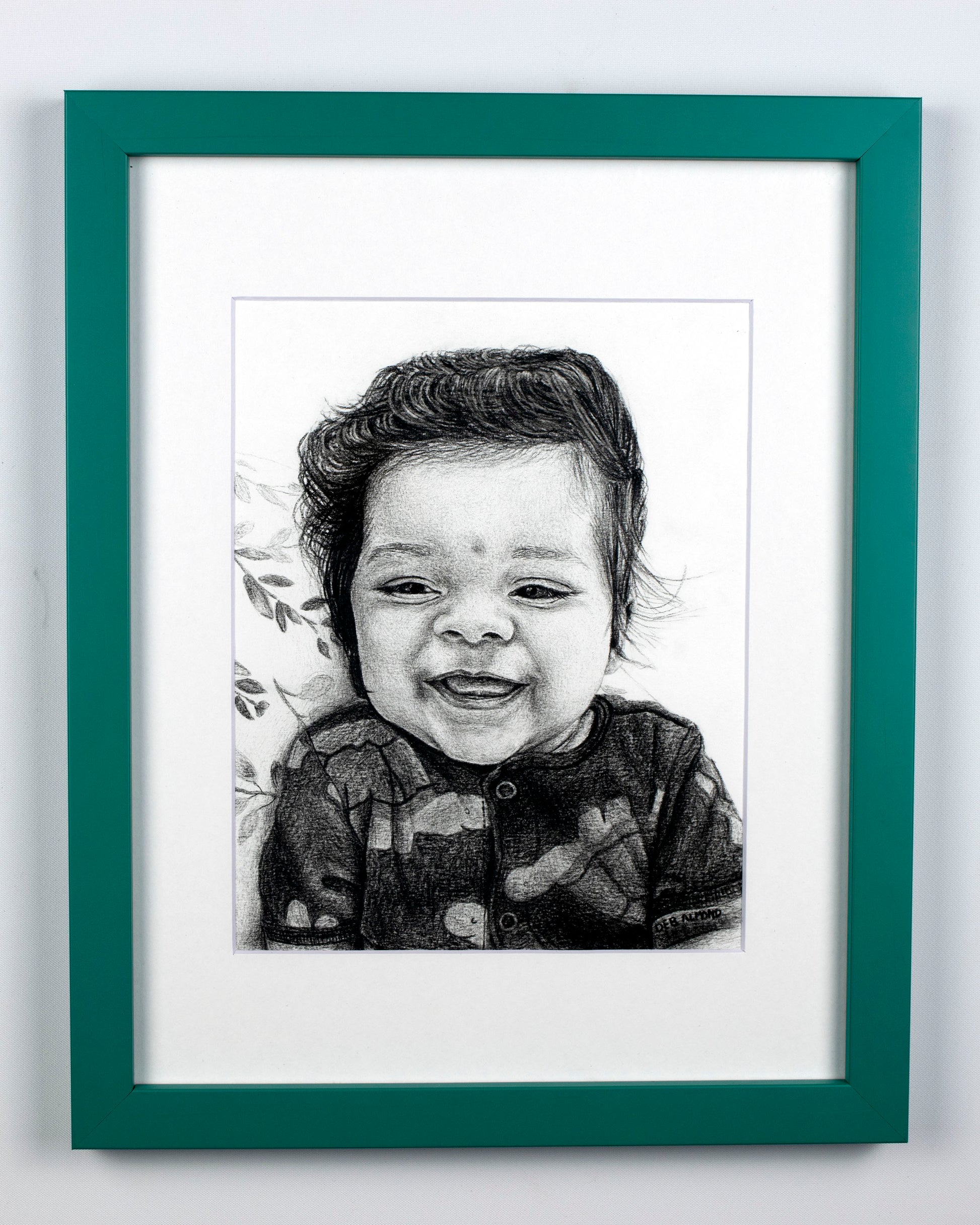 Portrait of a baby boy smiling with a green frame.