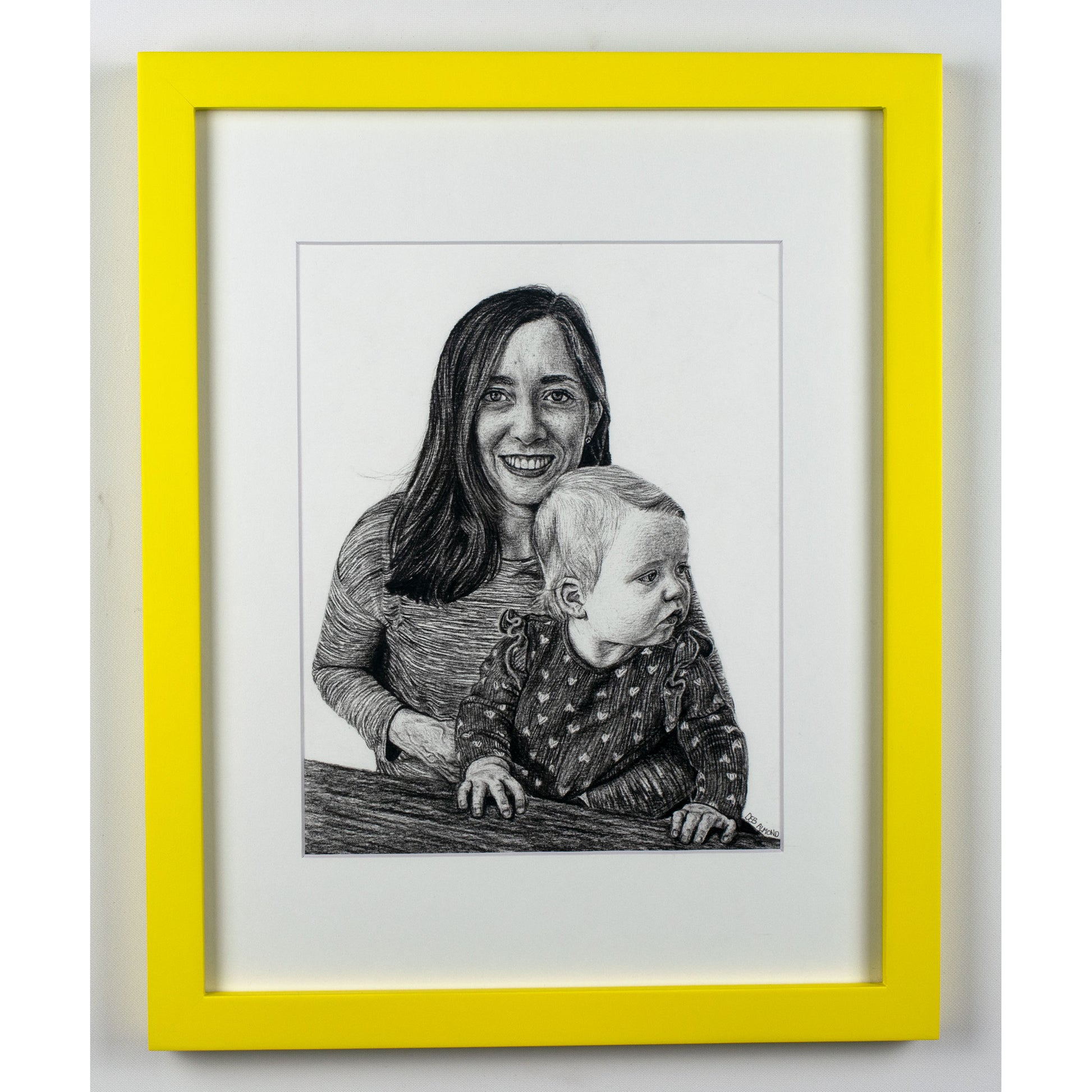 Portrait of a mom with her baby girl in a yellow frame.