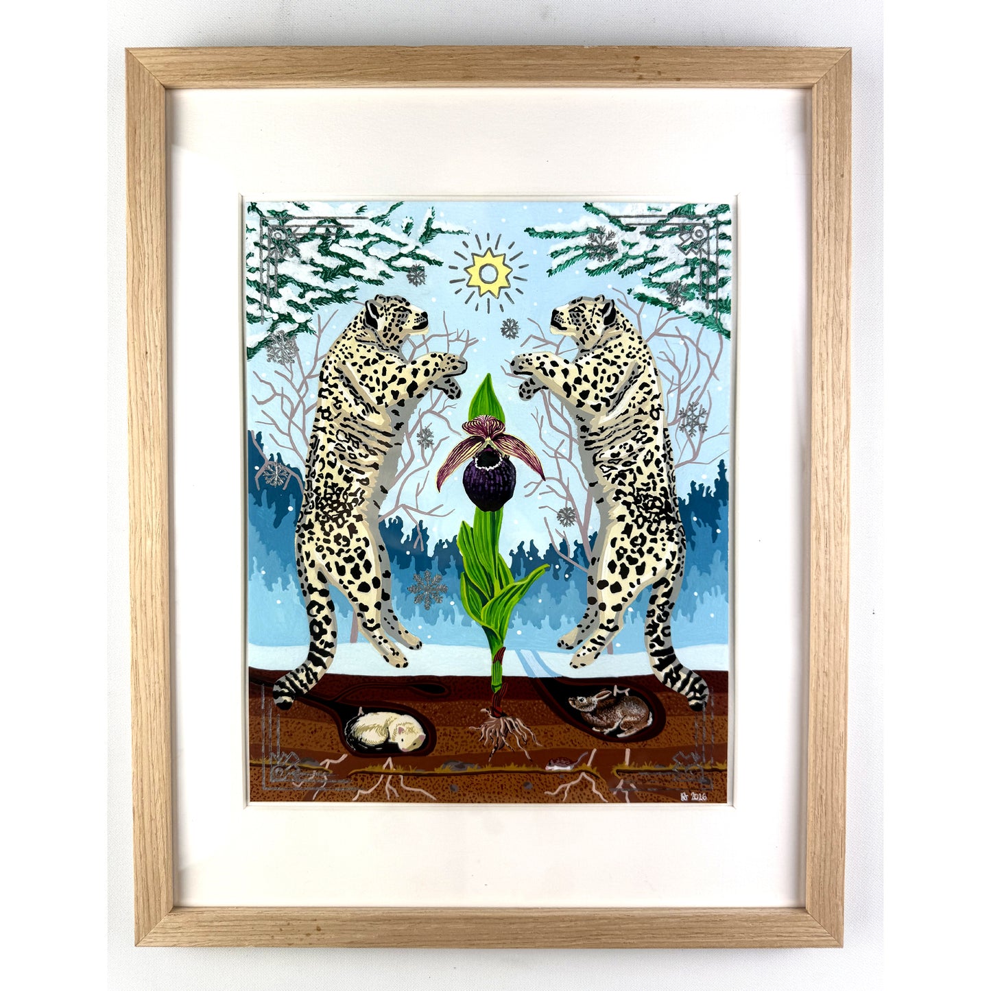 Straight-on view of a framed artwork featuring two snow leopards rearing symmetrically on either side of a central orchid in a snowy winter landscape, housed inside a light oak wood frame with a white window mat.