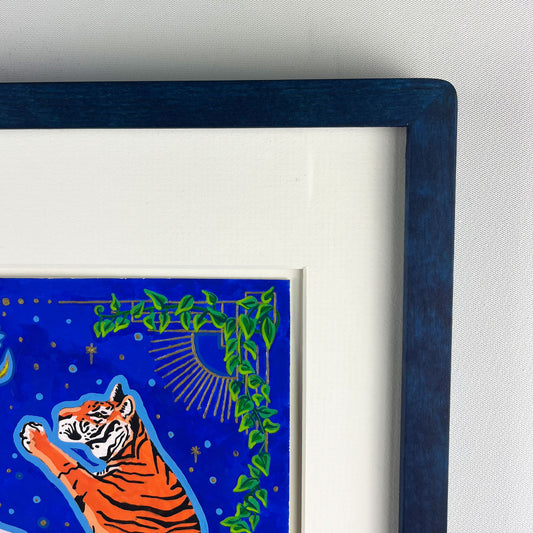 The top right corner of a vibrant illustration featuring one of two orange and black striped tigers standing upright. The background is a deep blue night sky and decorative green vines. The artwork is matted and framed in a dark blue frame.