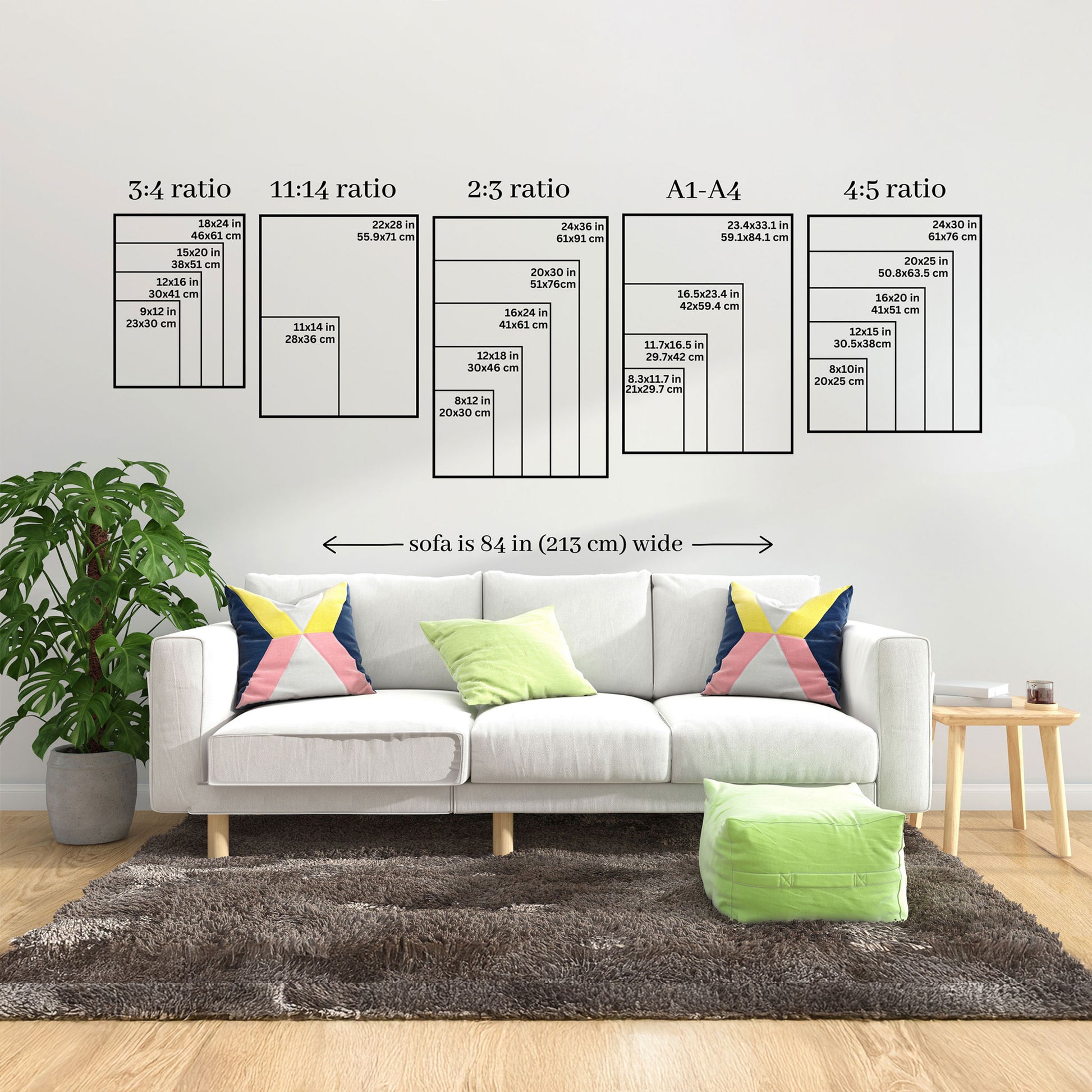 A living room scene showing a white sofa with colorful pillows, a green rug, and wall decals displaying poster and sofa size measurements in centimeters and inches.