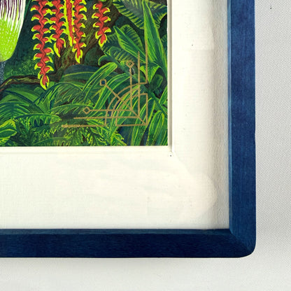 Close-up of the bottom right corner of a framed jungle print, showing the textured dark blue wood frame, white mat board, gold art deco design, and artist signature. By Deb Almond Art